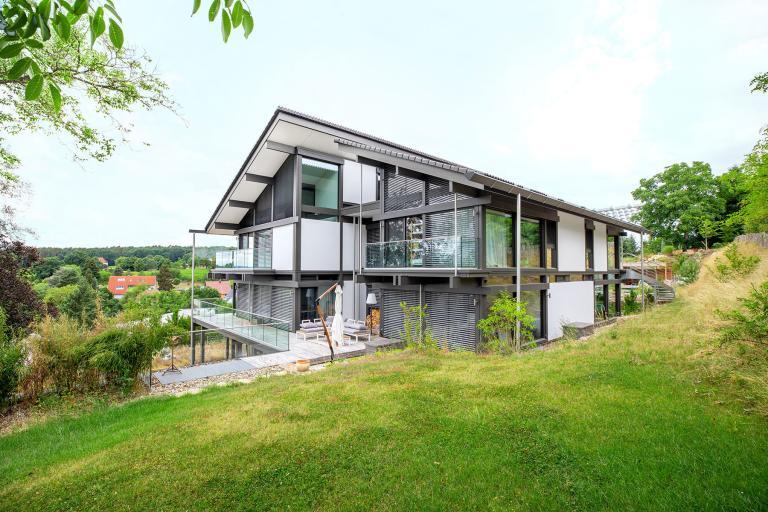 Aufnahme eines modernen Wohnhauses mit Garten und BRAUN Keller in Hanglage