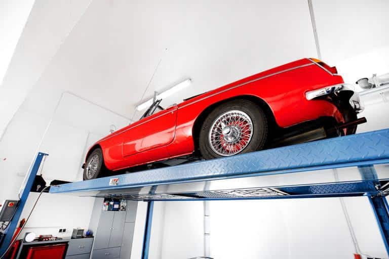 Rotes Auto auf einem Parklift in einem BRAUN Keller
